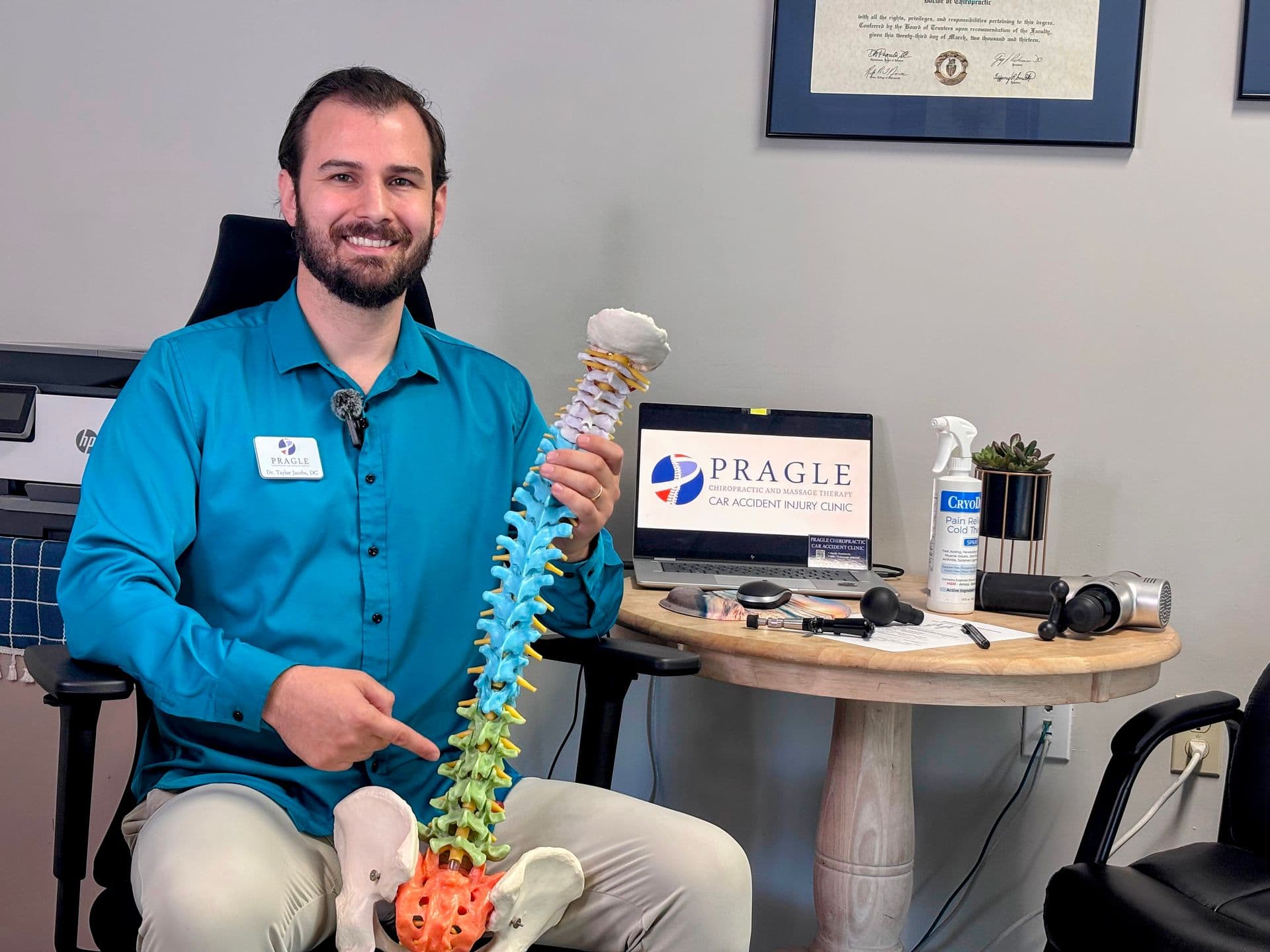 Chiropractor holding spine model, demonstrating expertise in auto injury treatment
